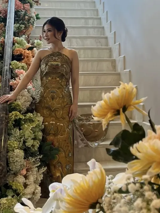 Saat prosesi sangjit, Putri tampil mengenakan dress berkerah tinggi warna gold dengan bordiran yang begitu detail. [@melindalamora]