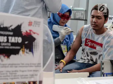 Petugas Komunitas Gerak Bareng melakukan proses penghapusan tato dalam acara Hijrah Fest 2018 di Jakarta, Sabtu (10/11). Program ini dilakukan secara gratis. (Liputan6.com/Faizal Fanani)