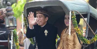Dengan Kereta Kencana, rombongan keluarga besar Presiden Joko Widodo saat itu hendak menuju ke lokasi pernikahan Kahiyang dan Bobby di Graha Saba Buana. Lambaian tangan dan senyuman terus diberikan Jokowi. (Adrian Putra/Bintang.com)