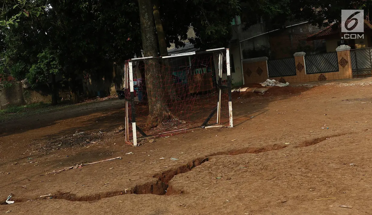 Penampakan tanah terbelah di lapangan RT 02 RW 02 Kampung Pedurenan, Kelurahan Cisalak Pasar, Cimanggis, Depok, Jabar, Senin (22/10). Penyelidikan tanah terbelah untuk mengetahui penyebab dan penanganan lanjutannya. (Liputan6.com/Immanuel Antonius)
