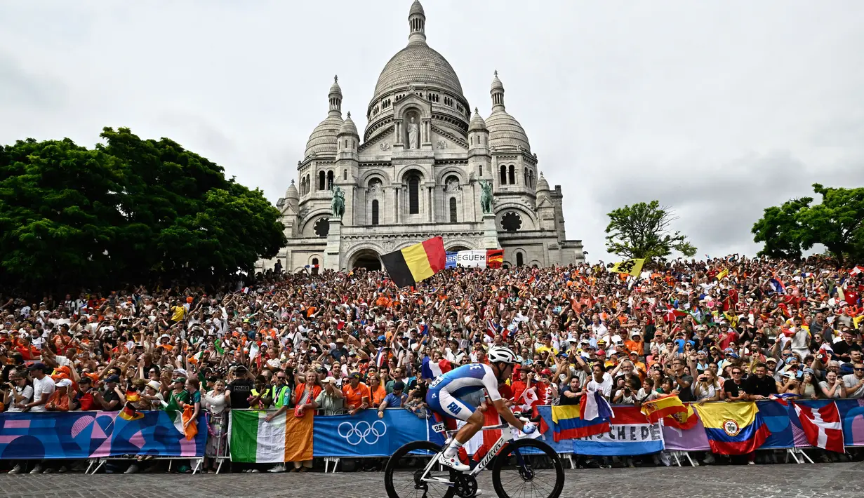 Valentin Madouas dari Prancis bersepeda melewati Basilika Sacre Coeur saat perlombaan balap sepeda jalan raya putra dalam Olimpiade Paris 2024, pada 3 Agustus 2024. (JULIEN DE ROSA/AFP)