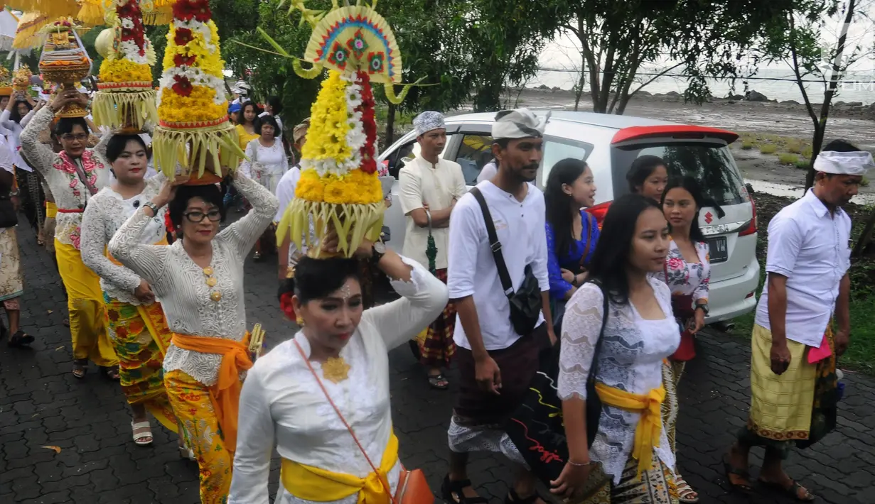 Umat Hindu membawa sesajen saat melaksanakan ritual Melasti di Kawasan Pantai Marina, Semarang, Jawa Tengah, Minggu (11/3). Ritual dilakukan ini untuk menyambut Hari Raya Nyepi. (Liputan6.com/Gholib)