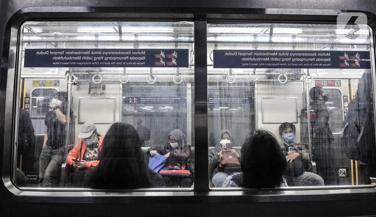 Penumpang menaiki kereta Commuter Line di Stasiun Manggarai, Jakarta, Selasa (12/1/2021). Selama PSBB di DKI mulai 11-25 Januari, PT Kereta Commuter Indonesia (KCI) memangkas jadwal operasional KRL menjadi pukul 04.00 WIB hingga 22.00 WIB guna menekan penularan Covid-19. (merdeka.com/Iqbal Nugroho)