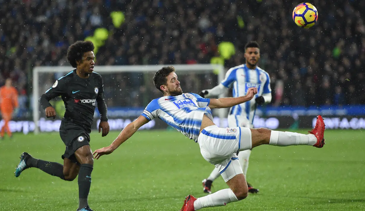 Bek Huddersfield, Tommy Smith, membuang bola dari kejaran gelandang Chelsea, Willian, pada laga Premier League di Stadion John Smith, Huddersfield, Selasa (12/12/2017). Huddersfield kalah 1-3 dari Chelsea. (AFP/Oli Scarff)