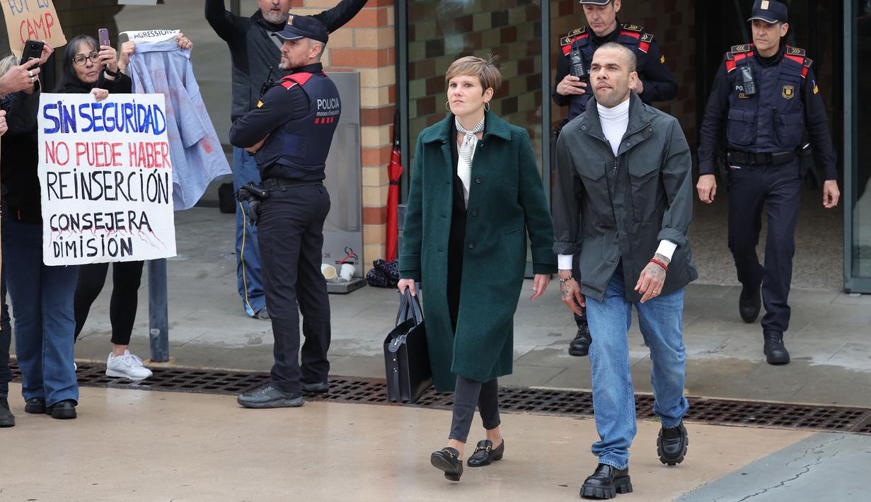 Pemain Brasil, Dani Alves (kanan) bersama pengacaranya, Ines Guardiola berjalan meninggalkan penjara Brians 2 di San Esteban Sasroviras, Barcelona, Spanyol, 25 Maret 2024. Alves bebas dari penjara setelah membayar uang jaminan 1 juta euro ke Pengadilan Barcelona. (AFP/Lluis Gene)