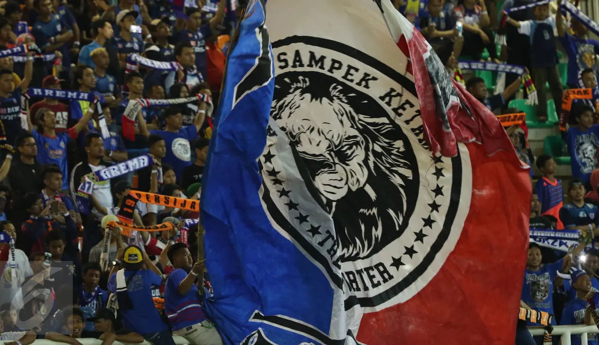 Suporter Arema FC mengibarkan bendera saat merayakan kemenangan atas PBFC di final Piala Presiden 2017 di Stadion Pakansari, Kab Bogor, Minggu (12/3). Arema FC juara Piala Presiden 2017. (Liputan6.com/Helmi Fithriansyah)