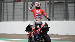 Pebalap Ducati, Andrea Dovizioso berselebrasi merayakan kemenangan MotoGP Grand Prix Valencia di arena balapan Ricardo Tormo, Cheste, Minggu (18/11). Andrea membukukan waktu 24 menit 3,408 detik terhitung pada sesi kedua. (Jose Jordan/AFP)
