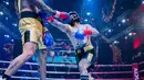 Pemain drum Superman is Dead, Jerinx (kanan), melakukan pukulan kearah perut dari Komika, Uus, dalam pertandingan tinju Holywings Sport Show (HSS) Series 3 yang berlangsung di Atlas Super Club, Bali, Minggu (10/9/2023). (Dok. Holywings)