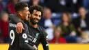 Striker Liverpool, Roberto Firmino, melakukan selebrasi bersama Mohamed Salah usai membobol gawang Burnley pada laga Premier League 2019 di Stadion Turf Moor, Sabtu (31/8). Liverpool menang 3-0 atas Burnley. (AP/Anthony Devlin)