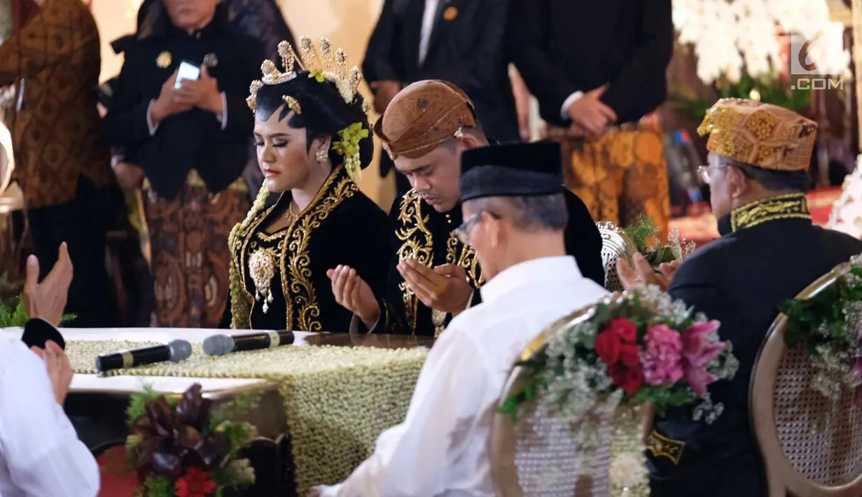 Putri Presiden Jokowi, Kahiyang Ayu dan Bobby Nasution berdoa setelah melaksanakan ijab kabul di Gedung Graha Saba, Sumber, Solo, Jawa Tengah, Rabu (8/11). (Liputan6.com/Pool/Jimboengphoto)