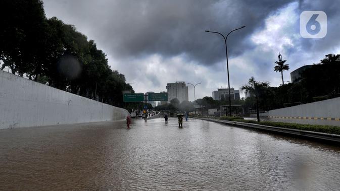 Suasana banjir yang menggenangi Jalan Tol JORR di kawasan TB Simatupang, Jakarta Selatan, Sabtu (20/2/2021). Banjir terjadi akibat luapan Kali Serua yang berada di pinggir jalan tol. (merdeka.com/Arie Basuki)