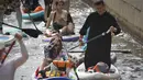 Orang-orang mengayuh papan stand-up paddle (SUP) mereka di sepanjang Griboyedov Channel  selama yang diberi nama Festival Fontanka-SUP di Sungai Moyka, St. Petersburg, Rusia, Sabtu, 6 Agustus 2022. Para peserta  tampak menikmati menghabiskan waktu dengan mendayung menyusuri sungai. (AP Photo/Dmitri Lovetsky)