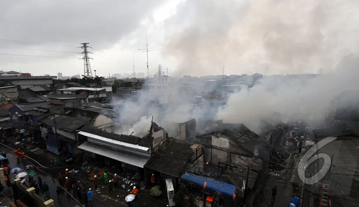 Asap membumbung usai petugas Damkar menjinakkan api yang membakar sejumlah rumah di kawasan Pasar Kembangan, Senen, Jakarta, Senin (19/1/2015).  (Liputan6.com/Miftahul Hayat)