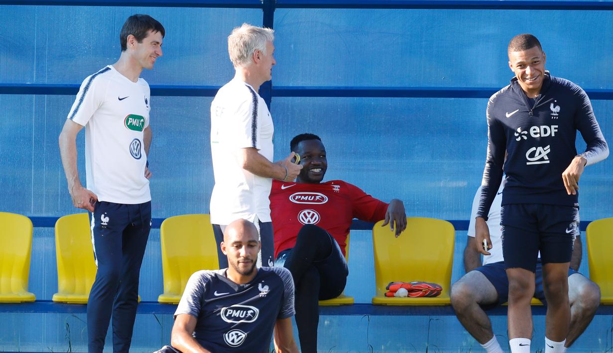 Penyerang Timnas Prancis, Kylian Mbappe (kanan) tersenyum saat mengikuti sesi latihan di Glebovets, Rusia, (12/7). Prancis akan bertanding melawan Kroasia pada babak Final Piala Dunia 2018. (AP Photo / David Vincent)