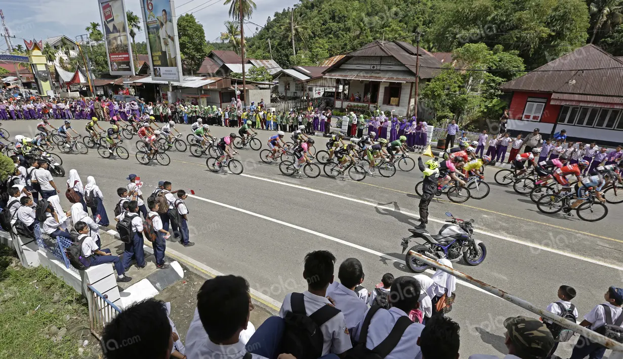 Antusias warga Painan saat menyambut pebalap pada etape ke-5 Tour de Singkarak dari Pantai Carocok-Painan menuju pantai Gondoriah-Pariaman, Sumatera Barart. (Bola.com/Nicklas Hanoatubun)