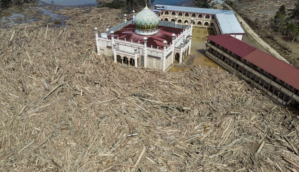 Pemandangan udara menunjukkan sisa-sisa pepohonan yang tumbang di pesantren dan masjid Darul Mukhlisin setelah banjir bandang di Aceh Tamiang, pada Rabu 10 Desember 2025. Banjir bandang dan tanah longsor yang menerjang Aceh, Sumatera Utara, dan Sumatera Barat yang terjadi beberapa pekan lalu mengakibatkan kerusakan parah pada sejumlah wilayah. (Aditya Aji/AFP)