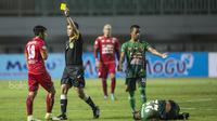 Gelandang Arema FC, Ahmad Bustomi, menerima kartu kuning saat melawan PS TNI pada laga Liga 1 di Stadion Pakansari, Bogor, Senin (3/7/2017). Kedua klub bermain imbang 0-0. (Bola.com/Vitalis Yogi Trisna)