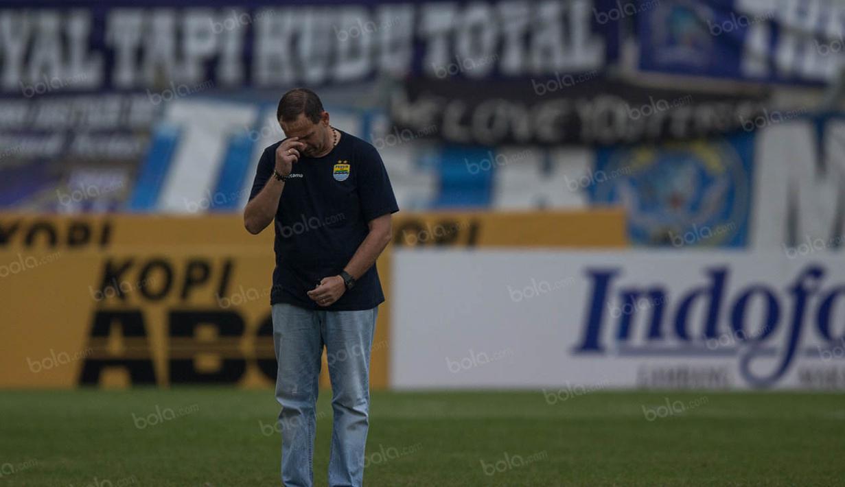 Pelatih Persib, Dejan Antonic, membuat tanda salib sesuai ajaran agama Katolik sebelum laga melawan Madura United. (Bola.com/Vitalis Yogi Trisna)
