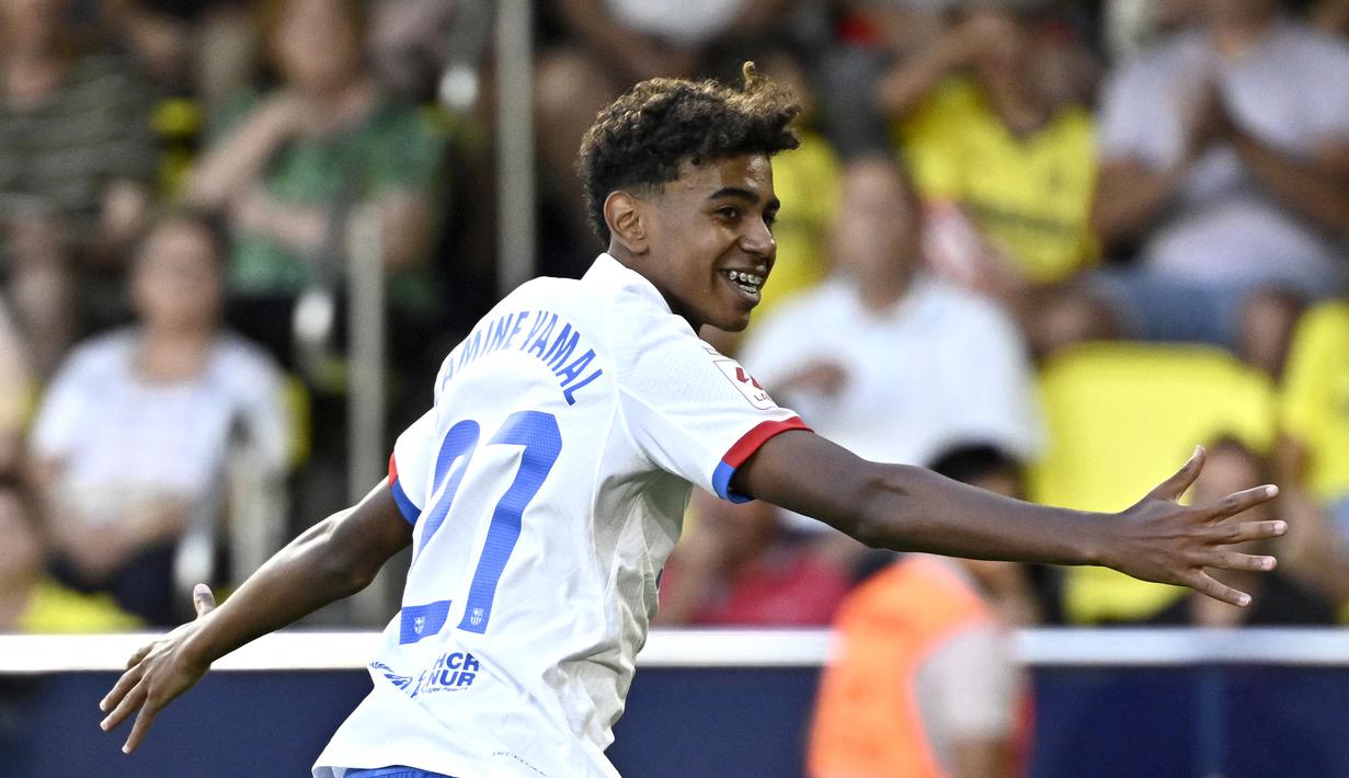 Pemain Barcelona, Lamine Yamal, merayakan gol ke gawang Villarreal pada laga Liga Spanyol 2023/2024 di Stadion La Ceramica, Minggu (27/8/2023). Barca menang dengan skor 4-3. (AFP/Javier Soriano)
