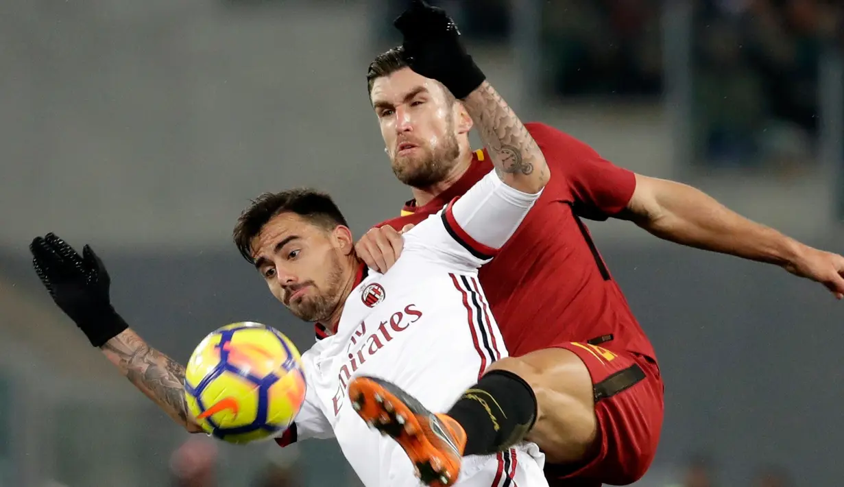 Pemain AC Milan, Suso  berebut bola dengan pemain AS Roma, Kevin Strootman pada laga pekan ke-26 Serie A di Stadion Olimpico, Senin (26/2). AC Milan yang bertindak sebagai tamu menang 2-0 atas tuan rumah AS Roma. (AP/Alessandra Tarantino)