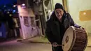 Mereka akan keluar memainkan drum dan menyanyikan lagu-lagu tradisional atau membaca puisi pendek tentang Ramadan. Tampak dalam foto, penabuh gendang Turki, Hakan Ozbingol, memainkan gendang dan menyanyikan lagu-lagu tradisional di jalanan Istanbul, untuk membangunkan umat Muslim untuk sahur, yaitu makan malam Ramadan, pada 24 Februari 2026. (Yasin AKGUL/AFP)