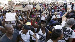 Pelajar membawa poster saat demonstrasi di luar Parlemen Afrika Selatan di Cape Town, Rabu (21/10). Polisi anti huru hara menembakkan gas airmata kepada ratusan pelajar yang berdemonstrasi menentang rencana kenaikan uang sekolah. (REUTERS/Mark Wessels)