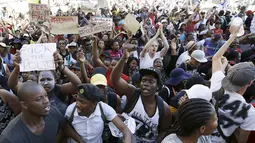 Pelajar membawa poster saat demonstrasi di luar Parlemen Afrika Selatan di Cape Town, Rabu (21/10). Polisi anti huru hara menembakkan gas airmata kepada ratusan pelajar yang berdemonstrasi menentang rencana kenaikan uang sekolah. (REUTERS/Mark Wessels)