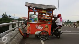 Pedagang minuman menjajakan dagangan menggunakan gerobak di atas jalan layang Pasar Rebo, Jakarta, Sabtu (14/1). Padahal aktivitas tersebut berbahaya bagi keselamatan mereka serta pengendara lain. (Liputan6.com/Immanuel Antonius)