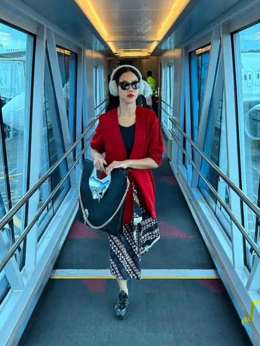 Yura Yunita tampil dengan oversize blazer merah dan inner hitamnya, dipadukan bawahan kain lilit batik serta sneakersnya. [@yurayunita]
