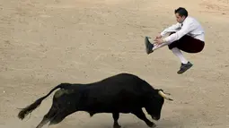 Seorang matador menghindari tandukkan banteng di arena adu banteng Canaveralejo di Cali, Kolombia, Senin (21/12/2014). (AFP Photo/Luis Robayo)