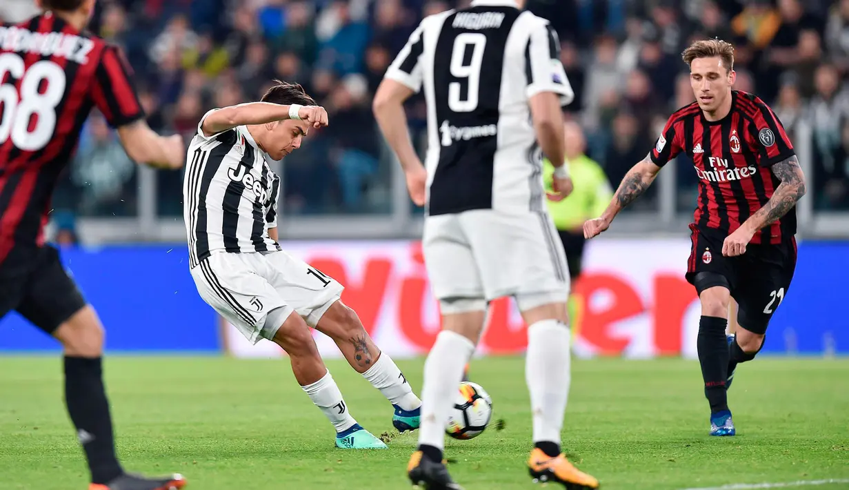 Striker Juventus Paulo Dybala melakukan tendangan yang akhirnya berbuah gol saat melawan AC Milan pada pertandingan Serie A Italia di Stadion Allianz di Turin (31/3). Dybala berhasil menyumbang satu gol untuk Juventus. (Alessandro Di Marco/ANSA via AP)