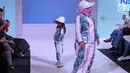 Seorang anak bersama ibunya berpose saat mengikuti fashion show Fabalous Mom and Kids 2018 di Fimela Fuchsia Market 2018 di Kota Kasablanka, Jakarta (27/5). (Liputan6.com/Faizal Fanani)