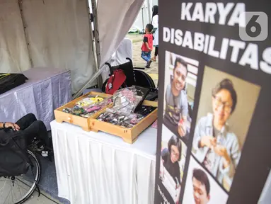 Penyandang disabilitas menjaga booth pada acara puncak peringatan Hari Disabilitas Internasional 2019 di Plaza Barat Gelora Bung Karno, Jakarta, Selasa (3/12/2019). Acara ini mengangkat tema 'Indonesia Inklusi, Disabilitas Unggul'. (Liputan6.com/Faizal Fanani)