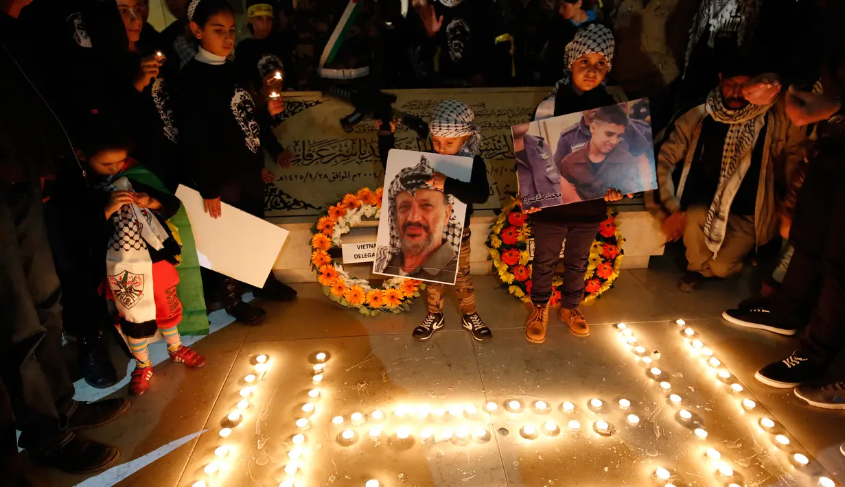 Warga Palestina menyalakan lilin dalam acara renungan menjelang peringatan 11 tahun wafatnya mantan Presiden Yasser Arafat, di Ramallah, Tepi Barat, Selasa (10/11) malam waktu setempat. (AFP PHOTO / ABBAS Momani)