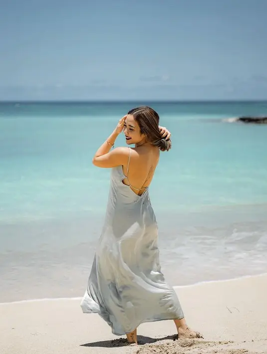 Gisel tampil dengan long dress satin backless warna hijau mint. Dress spaghetti strap yang memerlihatkan keindahan pundaknya.    Credit: Instagram/(@gisel_la)