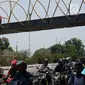 Kendaraan melintas di bawah proyek pembangunan Jembatan Penyebaran Orang (JPO) Pasar Minggu di Jakarta Selatan, Kamis (26/9/2019). JPO berdesain artistik senilai Rp 7 miliar tersebut ditargetkan rampung pengerjaannya pada Desember 2019 mendatang. (Liputan6.com/Immanuel Antonius)