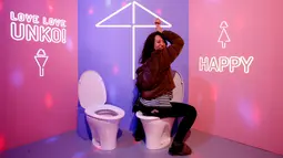 Seorang pengunjung berpose di toilet pajangan yang dipamerkan di Museum Unko di Yokohama, Jepang pada Rabu (17/4). Unko Museum Unko merupakan museum interaktif yang mengubah kotoran menjadi sesuatu yang lebih rapi dan bahkan lucu. (REUTERS/Kim Kyung-hoon)
