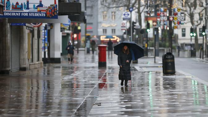 Seorang wanita melintas di jalan dekat Leicester Square, London, Inggris, 21 Desember 2020. Pada Minggu (20/12), Menteri Kesehatan Inggris Matt Hancock memperingatkan bahwa galur baru COVID-19 