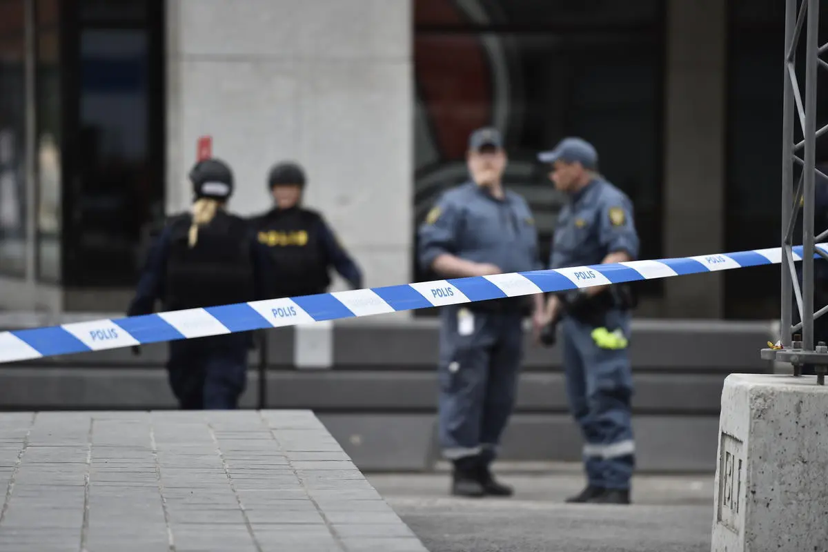 Polisi berjaga di sekitar lokasi serangan teror truk maut Swedia. (AP)