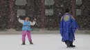 Seorang anak bermain salju di Istana Gyeongbok, Seoul, Korsel (13/12). Istana ini hancur pada saat invasi Jepang ke Korea tahun 1592-1598 dan dibangun lagi selama tahun 1860-an dengan 330 buah komplek bangunan dengan 5.792 kamar. (AFP Photo/Lee Jin-man)