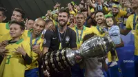 Kiper Brasil, Alisson, bersama rekan-rekannya merayakan gelar juara Copa America 2019 setelah mengalahkan Peru pada laga final di Stadion Maracana, Rio de Janeiro, Minggu (7/7). Brasil menang 3-1 atas Peru. (AFP/Carl De Souza)