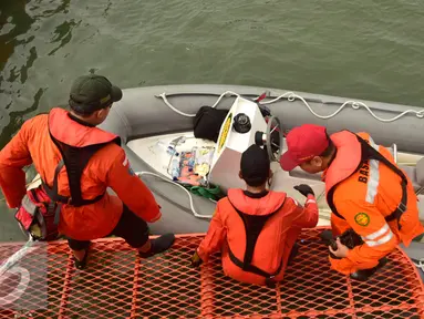Petugas  gabungan bersiap menaiki perahu karet saat mencari korban latihan terjun payung yang jatuh di seputar perairan pantai Semarang, Selasa (7/2). Korban adalah prajurit Kopassus yang diduga jatuh ke laut akibat cuaca buruk. (Liputan6.com/Gholib)