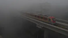 Kereta Metro Jalur Oranye (OLMT) melaju di tengah cuaca berkabut di Lahore (21/12/2022). Kabut tebal kembali menyelimuti berbagai kota di Punjab, termasuk Lahore pada malam hari antara Selasa dan Rabu, melumpuhkan kehidupan sehari-hari dan mengganggu lalu lintas jalan raya dan udara.(AFP/Arif Ali)
