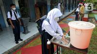 Para murid mencuci tangan saat akan melaksanakan uji coba pendidikan tatap muka (PTM) di SMPN 15, Kota Bogor, Jawa Barat, Senin (31/5/2021). Pemerintah Kota Bogor menggelar uji coba PTM di 37 sekolah hari ini dengan protokol kesehatan yang ketat. (merdeka.com/Arie Basuki)