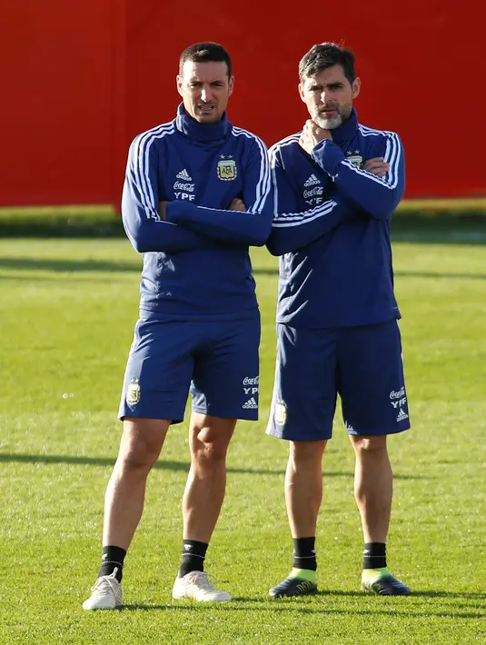 Pelatih Argentina Lionel Scaloni (kiri) dan asisten Roberto Ayala melihat para pemainnya latihan di Ciudad Deportiva Antonio Asensio di Palma de Mallorca (12/11/2019). Argentina akan memainkan pertandingan persahabatan melawan Brasil di Riyadh dan Uruguay di Tel Aviv. (AFP/Jaime Reina)