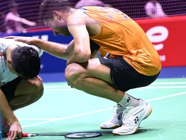 Pebulu tangkis Indonesia, Anthony Sinisuka Ginting (kiri) tertunduk usai dikalahkan Toma Junior Popov (Prancis) pada pertandingan tunggal putra di Kejuaraan Dunia BWF di Adidas Arena, Paris, pada 26 Agustus 2025. (Bertrand GUAY/AFP)