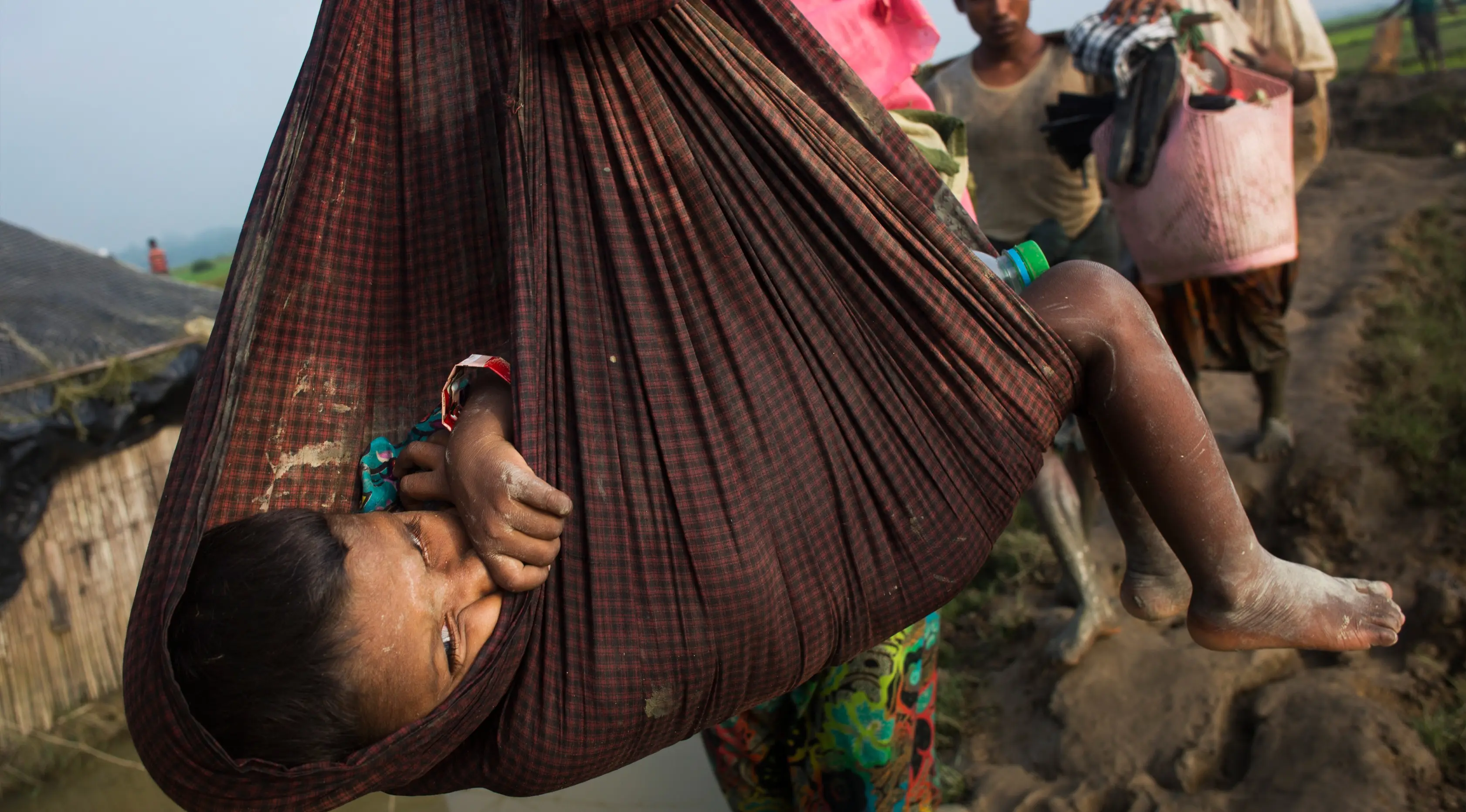 Seorang anak digendong ibunya saat mengungsi ke perbatasan Bangladesh di daerah Teknaf Cox's Bazar (5/9). Belasan ribu warga Rohingya melarikan diri ke Bangladesh, sejak bentrokan kembali pecah di Rakhine.(AP Photo/Bernat Armangue)