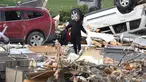 Seorang wanita berjalan melewati puing-puing yang menumpuk di luar sebuah restoran yang hancur akibat tornado pada 15 Maret 2024 di Winchester, Indiana. (Scott Olson/Getty Images North America/Getty Images via AFP)