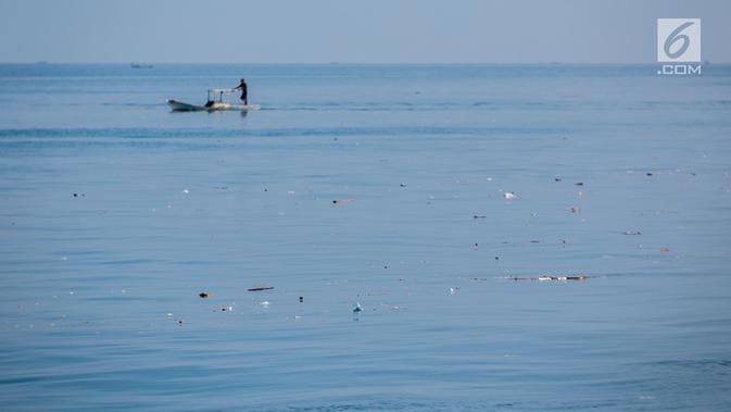 Nelayan berlayar di antara sampah kiriman yang mengotori perairan Kepulauan Seribu di sekitar Pulau Pari dan Pulau Pramuka, Rabu (28/11). Sampah berasal dari wilayah luar Jakarta yang terbawa angin hingga ke perairan Jakarta. (Liputan6.com/Faizal Fanani)
