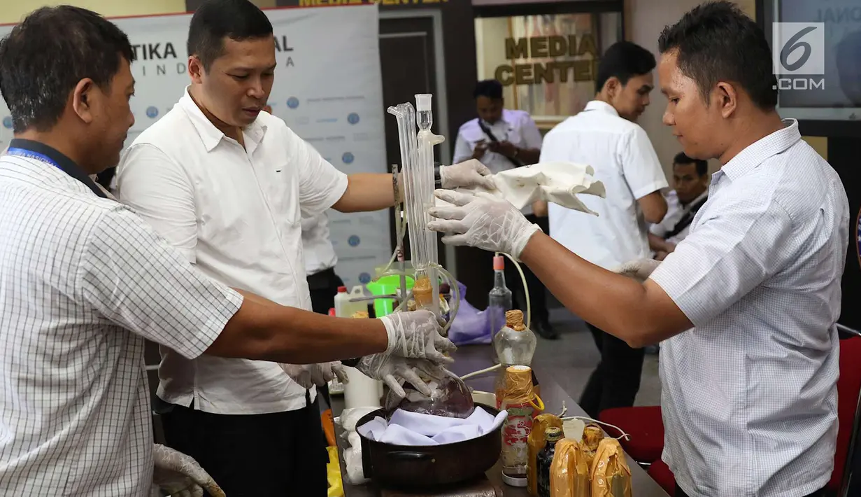 Petugas BNN memeriksa barang bukti dalam penggerebekan pabrik gelap narkoba di Majene di Gedung BNN Jakarta, Kamis (9/8). Petugas mengamankan barang bukti berupa narkotika dan bahan pembuatnya. (Liputan6.com/Immanuel Antonius)